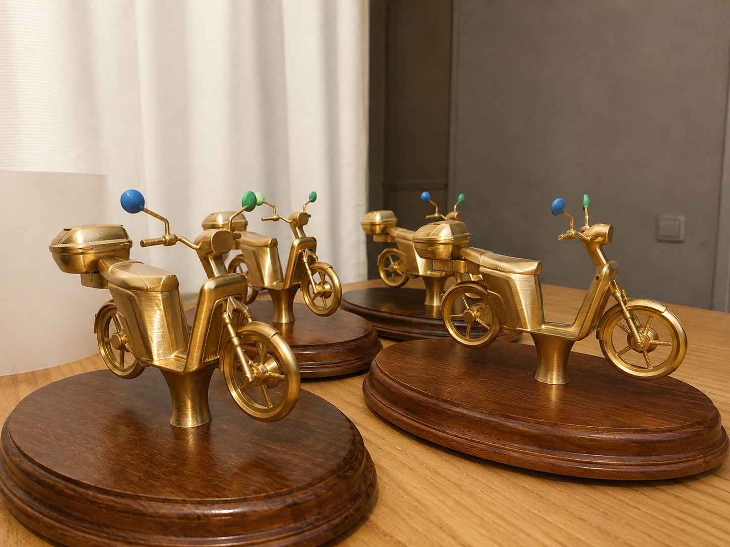 Trofeos dorados con forma de moto Cooltra sobre peanas de madera